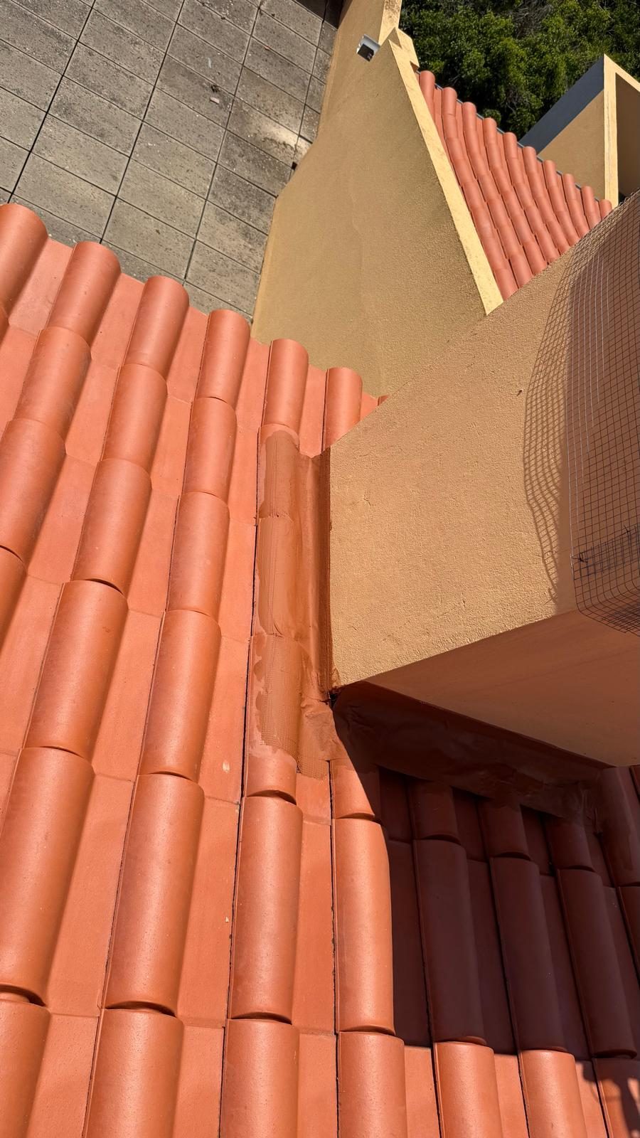 Encontro entre o telhado de telha cerâmica e a empena rebocada, com o remate já tratado